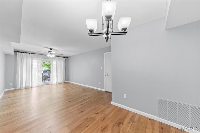 empty room featuring ceiling fan, baseboards, and light wood finished floors
