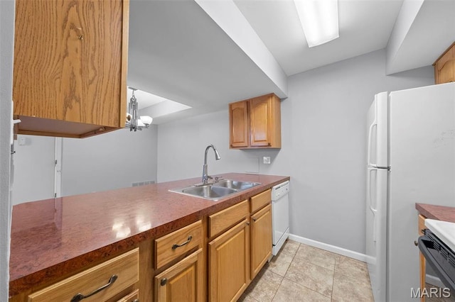 kitchen featuring white appliances, a sink, dark countertops, baseboards, and light tile patterned floors
