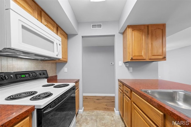 kitchen with range with electric stovetop, white microwave, tasteful backsplash, and dark countertops