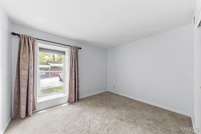 carpeted empty room with baseboards