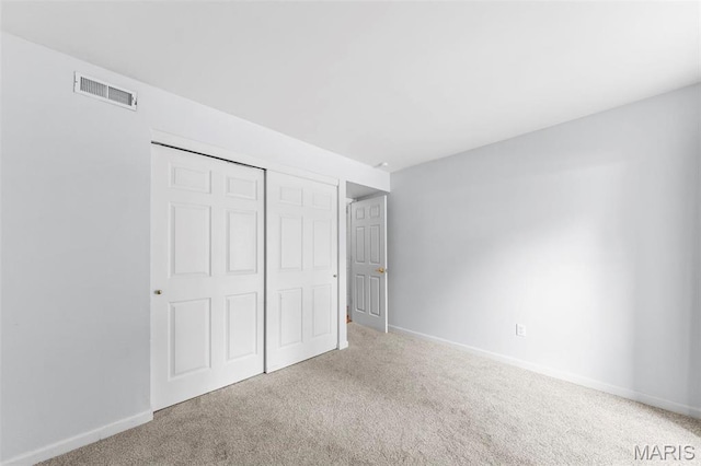 unfurnished bedroom with carpet flooring, baseboards, and a closet