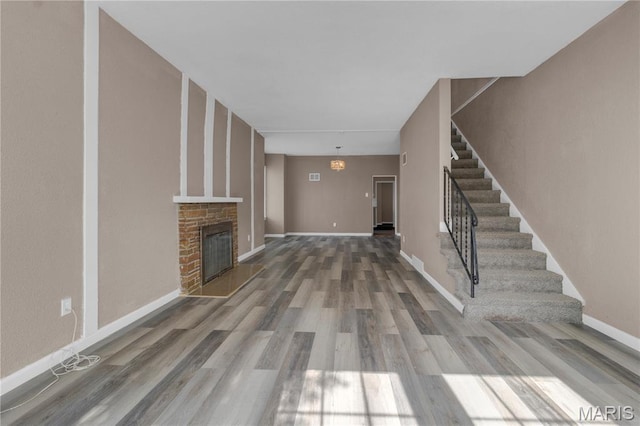 317 S Louisiana St, Cape Girardeau, MO 63703 - unfurnished living room with stairway, wood finished floors, a brick fireplace, and baseboards