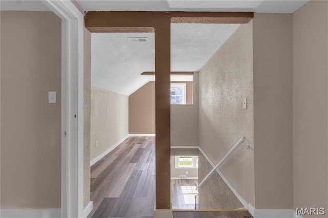 317 S Louisiana St, Cape Girardeau, MO 63703 - hall featuring wood finished floors, a textured wall, lofted ceiling, a textured ceiling, and baseboards