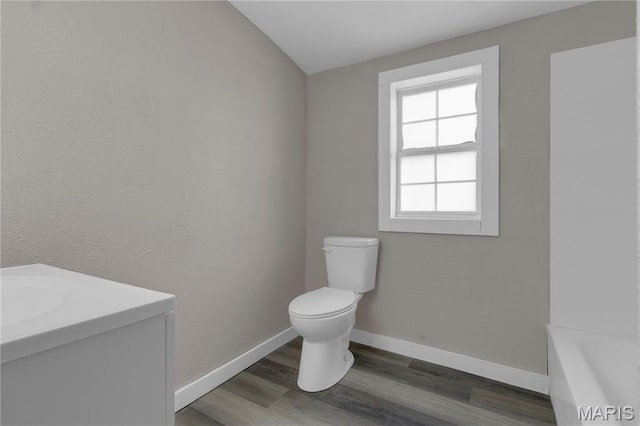 317 S Louisiana St, Cape Girardeau, MO 63703 - bathroom featuring toilet, wood finished floors, vanity, a tub, and baseboards
