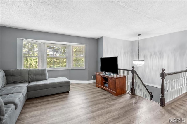 1748 Scenic Meadows Dr, Imperial, MO 63052 - living area with a chandelier, wood finished floors, a textured ceiling, and baseboards