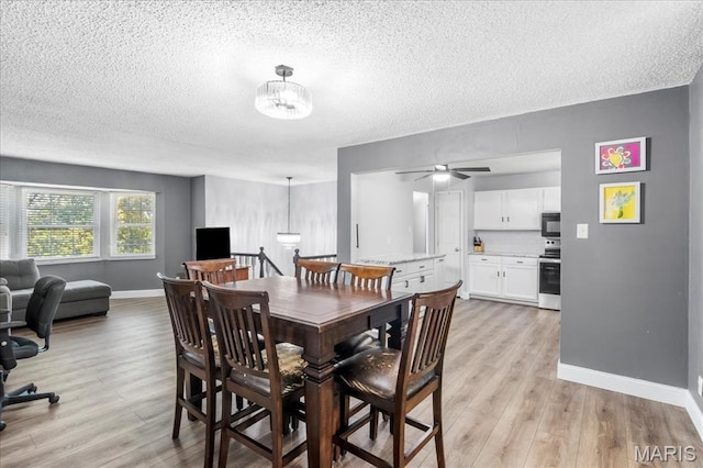 1748 Scenic Meadows Dr, Imperial, MO 63052 - dining area featuring a textured ceiling, baseboards, light wood-style floors, a chandelier, and a ceiling fan