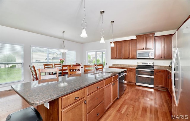 3 Lakeview Pointe Ct, Lake St Louis, MO 63367 - kitchen featuring appliances with stainless steel finishes, a sink, light wood-style floors, an island with sink, and a kitchen bar