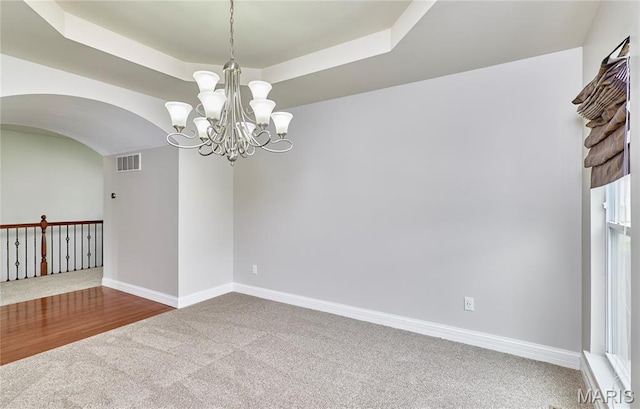 3 Lakeview Pointe Ct, Lake St Louis, MO 63367 - unfurnished room featuring carpet floors, a raised ceiling, a chandelier, arched walkways, and baseboards
