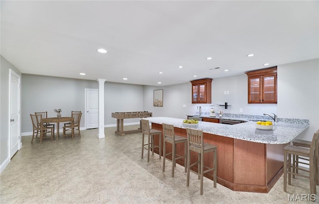 3 Lakeview Pointe Ct, Lake St Louis, MO 63367 - kitchen with a peninsula, recessed lighting, a breakfast bar, light stone counters, and glass insert cabinets