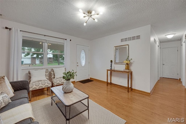 2794 Pinebrook Dr, Arnold, MO 63010 - living room with a textured ceiling, light wood-type flooring, and baseboards