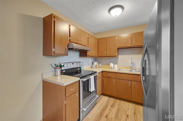 2794 Pinebrook Dr, Arnold, MO 63010 - kitchen featuring stainless steel appliances, under cabinet range hood, a sink, a textured ceiling, and light wood-style floors