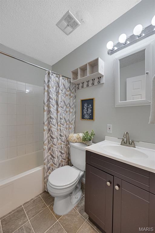 2794 Pinebrook Dr, Arnold, MO 63010 - full bath with vanity, toilet, shower / bath combination with curtain, a textured ceiling, and tile patterned flooring