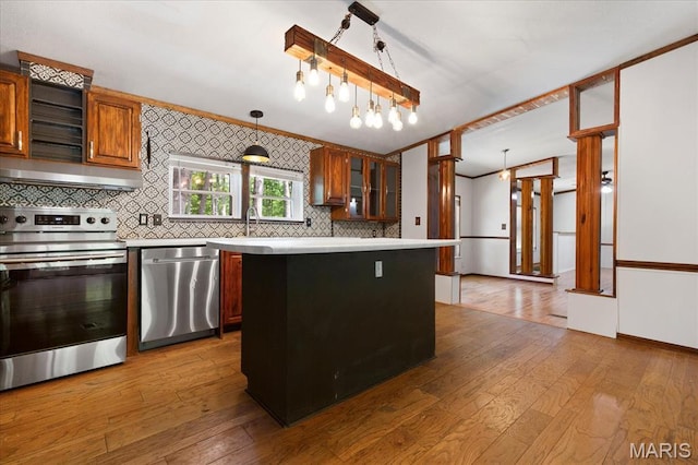 kitchen featuring appliances with stainless steel finishes, light countertops, tasteful backsplash, and wood-type flooring