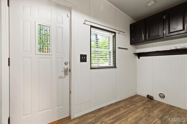 laundry room featuring cabinet space, wood finished floors, and baseboards