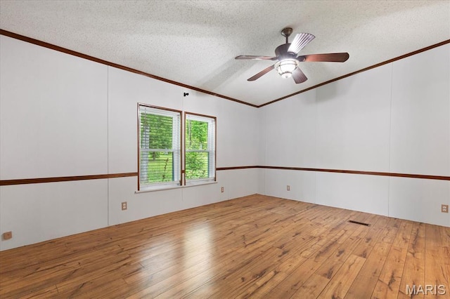 empty room featuring ornamental molding, a textured ceiling, wood-type flooring, and ceiling fan