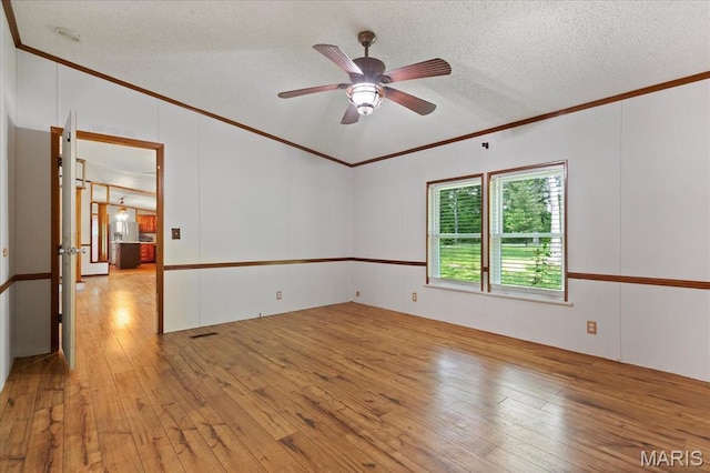 spare room with ornamental molding, hardwood / wood-style floors, a ceiling fan, and a textured ceiling