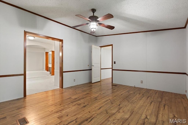 unfurnished room featuring ornamental molding, ceiling fan, a textured ceiling, and hardwood / wood-style floors