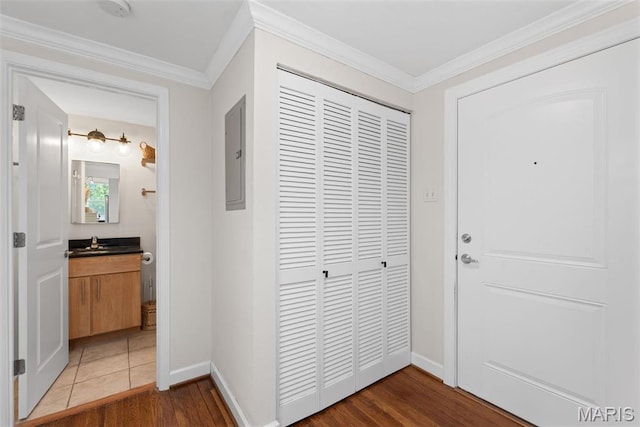 5621 Pershing Ave Unit 21, Saint Louis, MO 63112 - hallway with wood finished floors, baseboards, crown molding, electric panel, and a sink