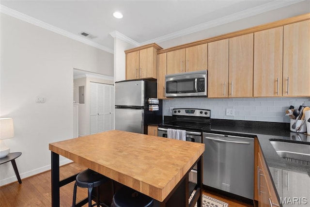 5621 Pershing Ave Unit 21, Saint Louis, MO 63112 - kitchen featuring stainless steel appliances, light brown cabinetry, decorative backsplash, crown molding, and wood finished floors