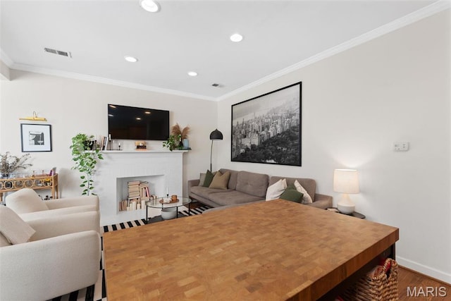 5621 Pershing Ave Unit 21, Saint Louis, MO 63112 - living area with crown molding, recessed lighting, a brick fireplace, wood finished floors, and baseboards