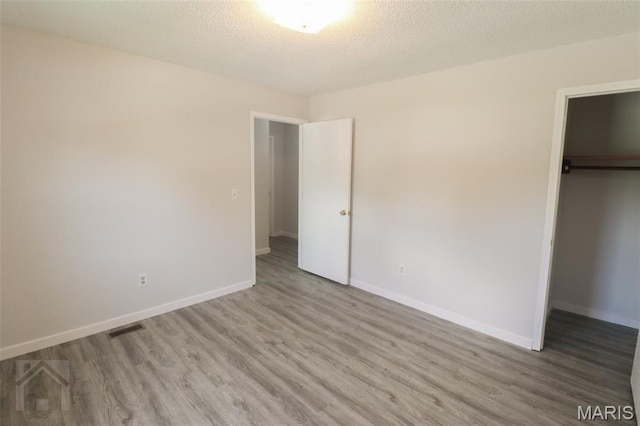 104 Wild Rose Pl, Saint Robert, MO 65584 - unfurnished bedroom featuring wood finished floors and a walk in closet