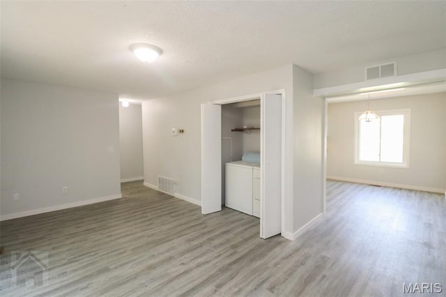 104 Wild Rose Pl, Saint Robert, MO 65584 - unfurnished room with light wood finished floors, a textured ceiling, and separate washer and dryer