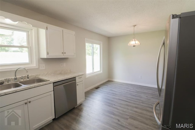 104 Wild Rose Pl, Saint Robert, MO 65584 - kitchen with stainless steel appliances, white cabinets, a textured ceiling, dark wood-style floors, and hanging light fixtures