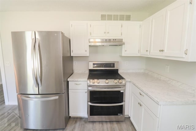 104 Wild Rose Pl, Saint Robert, MO 65584 - kitchen with stainless steel appliances, under cabinet range hood, light countertops, white cabinets, and light wood-type flooring