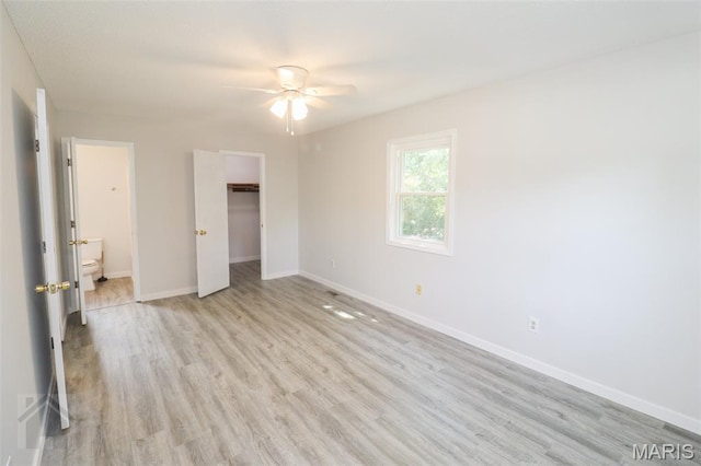 104 Wild Rose Pl, Saint Robert, MO 65584 - unfurnished bedroom featuring light wood-style flooring, a walk in closet, connected bathroom, and a ceiling fan