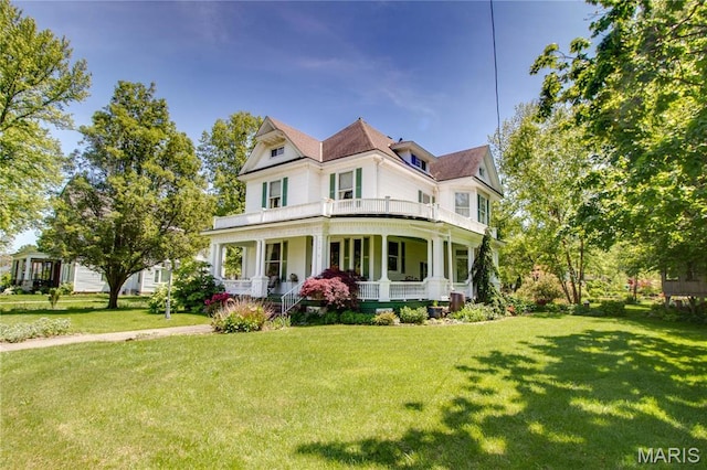 619 E Main St, Carlinville, IL 62626 - victorian home featuring a porch, a balcony, and a front yard