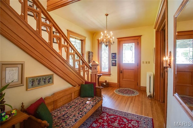 619 E Main St, Carlinville, IL 62626 - entryway with radiator heating unit, a chandelier, wood finished floors, and plenty of natural light