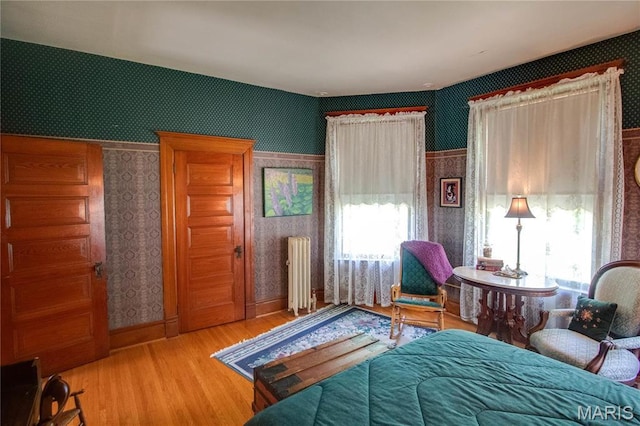 619 E Main St, Carlinville, IL 62626 - bedroom with wallpapered walls, radiator heating unit, wood finished floors, and baseboards