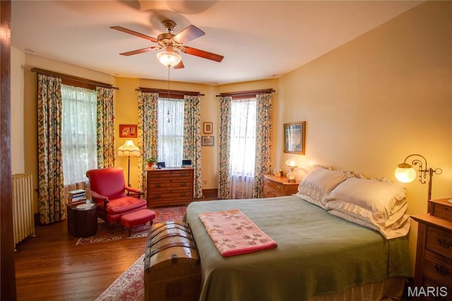 619 E Main St, Carlinville, IL 62626 - bedroom with wood finished floors, radiator heating unit, multiple windows, and ceiling fan
