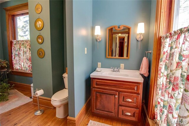 619 E Main St, Carlinville, IL 62626 - bathroom with wood finished floors, toilet, vanity, and baseboards
