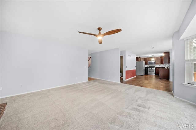 14 Sunderland Ct, Saint Charles, MO 63303 - unfurnished living room with carpet flooring, baseboards, ceiling fan, and stairway