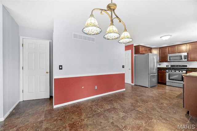 14 Sunderland Ct, Saint Charles, MO 63303 - kitchen with stainless steel appliances, baseboards, decorative light fixtures, and dark stone finish floors