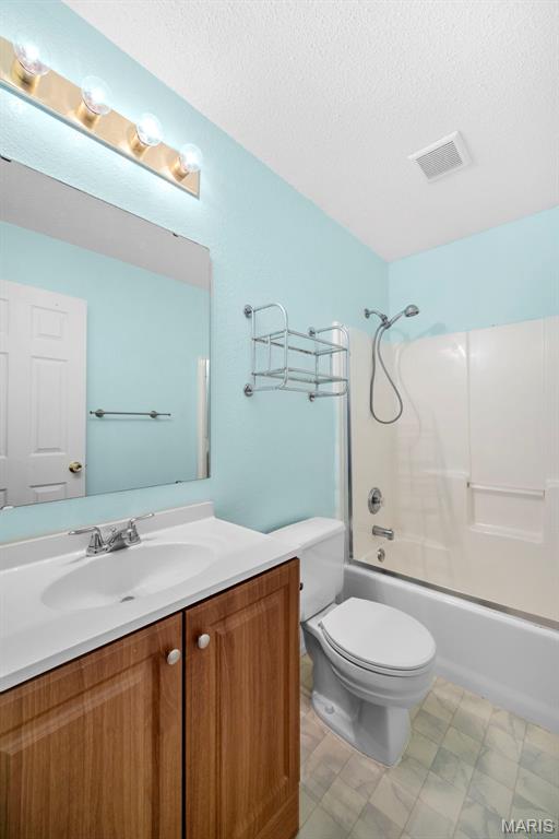 14 Sunderland Ct, Saint Charles, MO 63303 - bathroom featuring vanity, toilet, a textured ceiling, and shower / bath combination