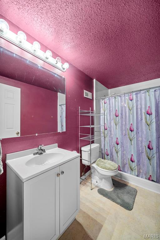 14 Sunderland Ct, Saint Charles, MO 63303 - full bathroom with toilet, vanity, a textured ceiling, tile patterned floors, and curtained shower