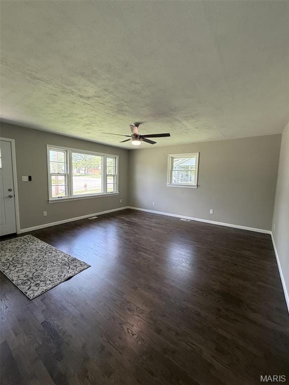 170 E Euclid Ave, Sullivan, MO 63080 - unfurnished living room featuring ceiling fan, healthy amount of natural light, baseboards, dark wood-type flooring, and a textured ceiling