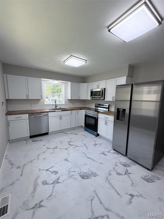 170 E Euclid Ave, Sullivan, MO 63080 - kitchen with appliances with stainless steel finishes, a sink, wood counters, and white cabinets
