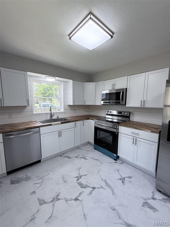 170 E Euclid Ave, Sullivan, MO 63080 - kitchen with wooden counters, appliances with stainless steel finishes, a sink, white cabinetry, and light marble finish flooring