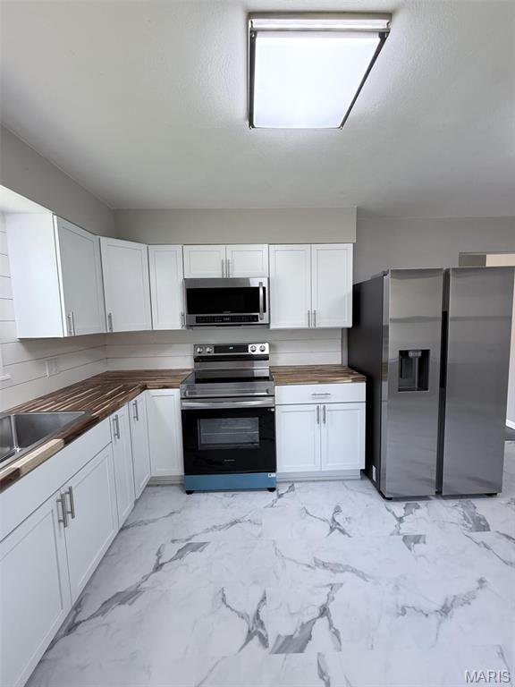 170 E Euclid Ave, Sullivan, MO 63080 - kitchen featuring stainless steel appliances, butcher block counters, light marble finish flooring, and white cabinetry