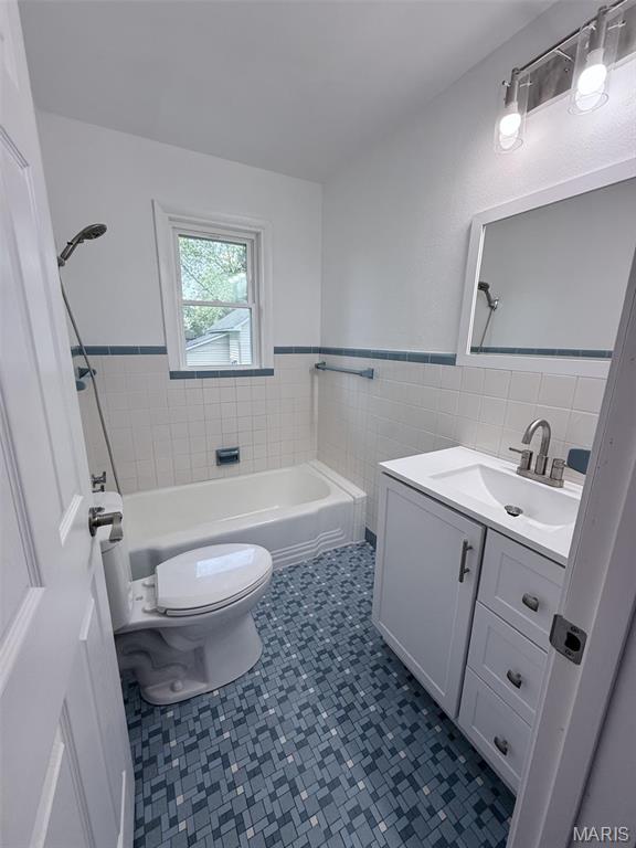 170 E Euclid Ave, Sullivan, MO 63080 - full bathroom with a bathtub, tile walls, toilet, vanity, and a wainscoted wall