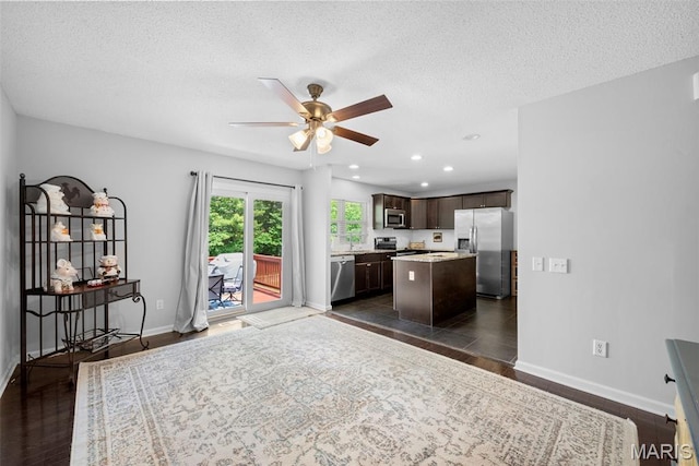 207 Straightoak, Ballwin, MO 63021 - kitchen featuring stainless steel appliances, dark brown cabinetry, ceiling fan, a center island, and light countertops