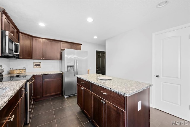 207 Straightoak, Ballwin, MO 63021 - kitchen with stainless steel appliances, a kitchen island, dark tile patterned flooring, dark brown cabinetry, and recessed lighting