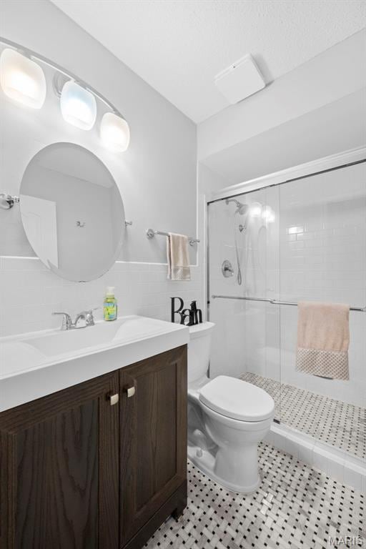 207 Straightoak, Ballwin, MO 63021 - bathroom featuring toilet, a stall shower, vanity, and tile walls