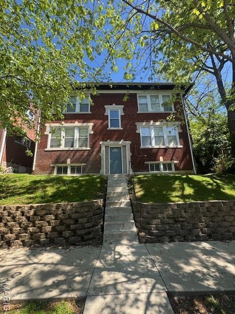 view of front of property with a front yard and brick siding