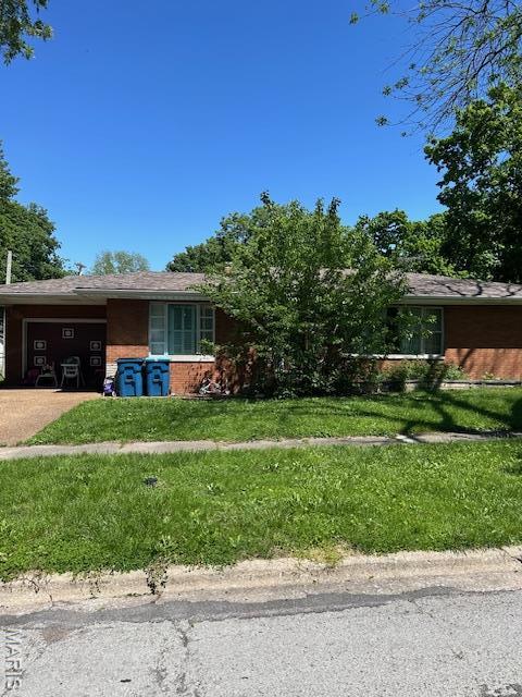 view of front of property featuring brick siding, a garage, a front yard, and concrete driveway
