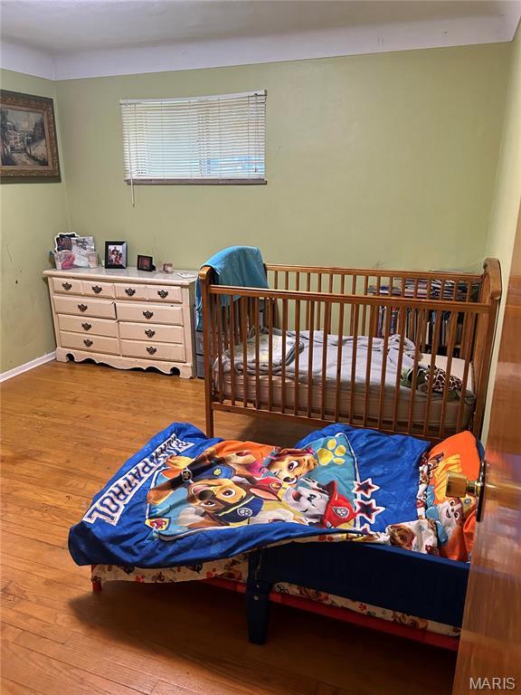 bedroom with hardwood / wood-style floors and baseboards