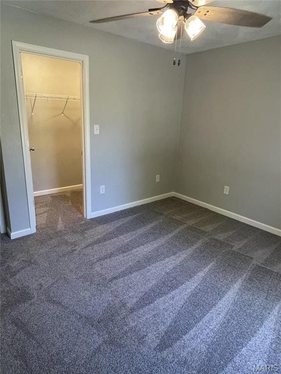 unfurnished bedroom with a spacious closet, carpet floors, baseboards, and a closet